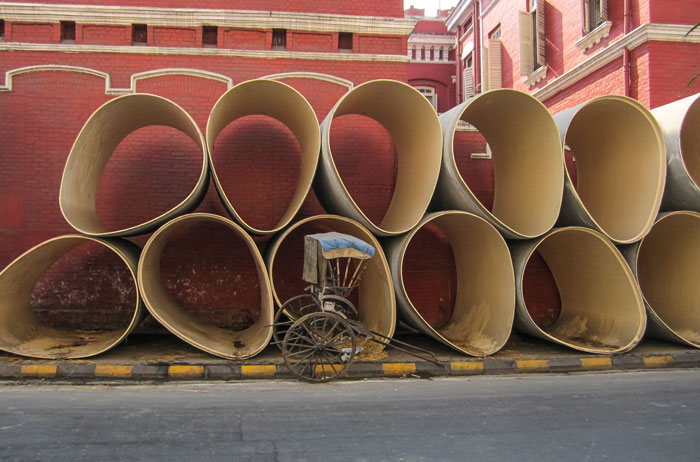 Rickshaw walla sleeping amid giant tubes
